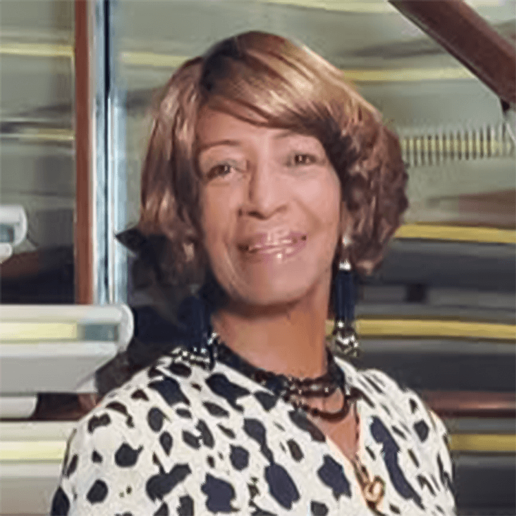 Woman smiling in a polka dot top.